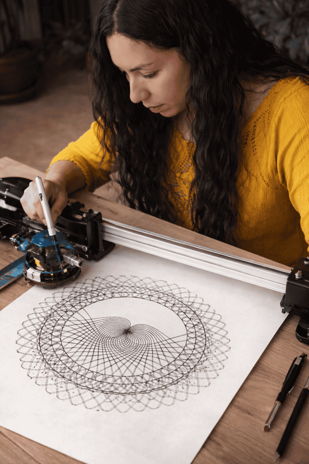 Mujer realiza geometría personalizada con estilógrafo sobre papel y tinta